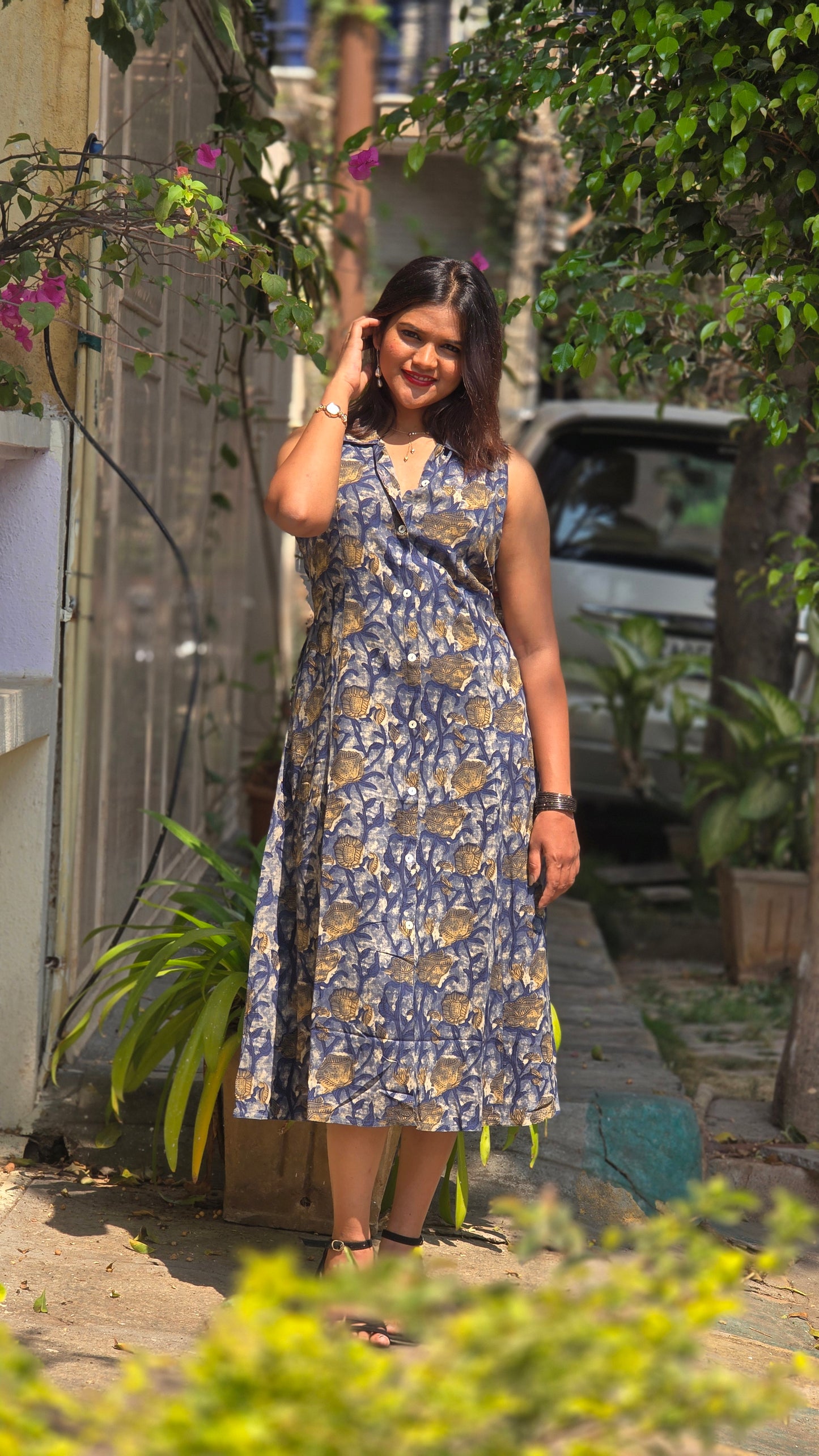 Blue floral sleeveless midi dress for women with button-down front and elegant flowy silhouette.