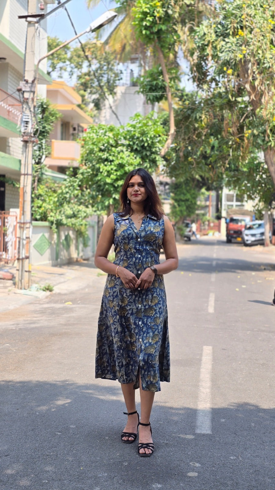 Blue floral sleeveless midi dress for women with button-down front and elegant flowy silhouette.