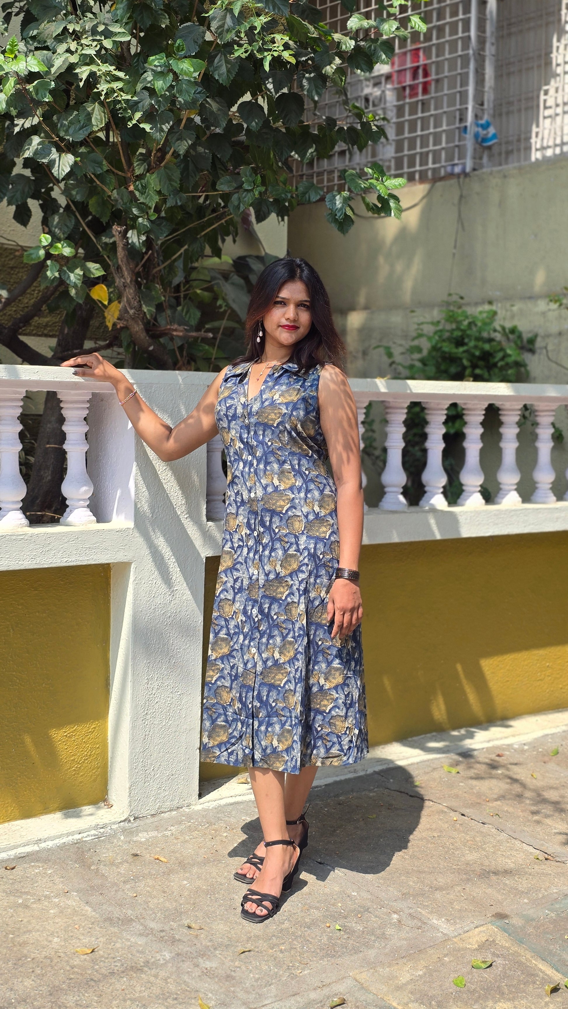 Blue floral sleeveless midi dress for women with button-down front and elegant flowy silhouette.